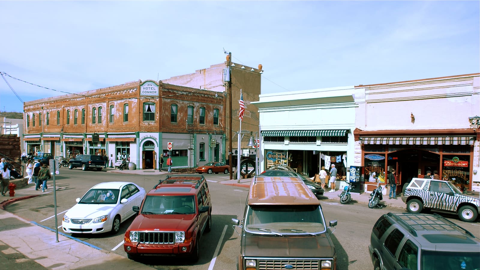 A view along Main Street in Jerome, Arizona, showing historic brick storefronts including the Hotel Connor building on a steep hillside street.
