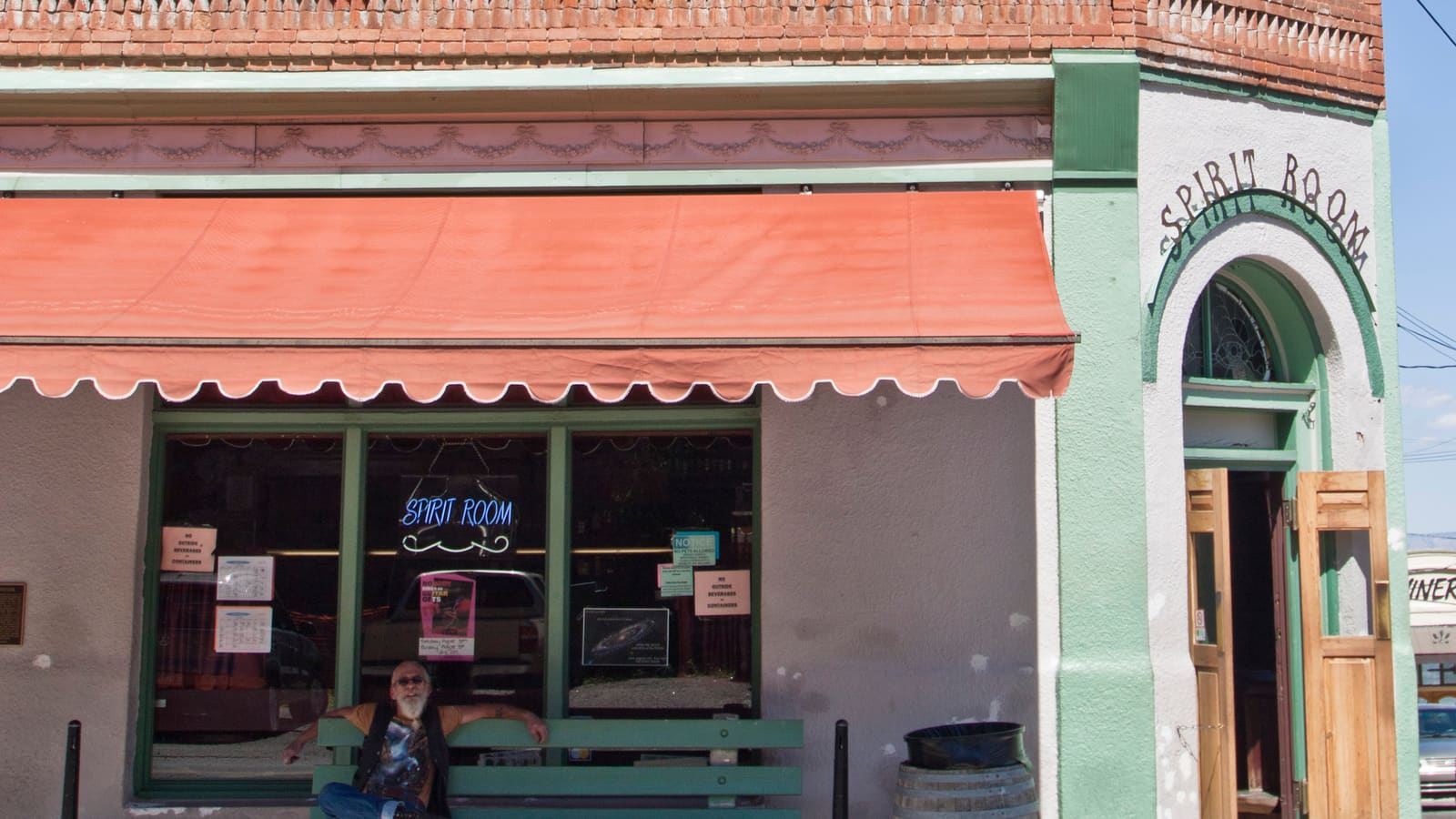 Exterior of the Spirit Room, a historic saloon in Jerome, Arizona, housed in a weathered brick building on the town's main street.