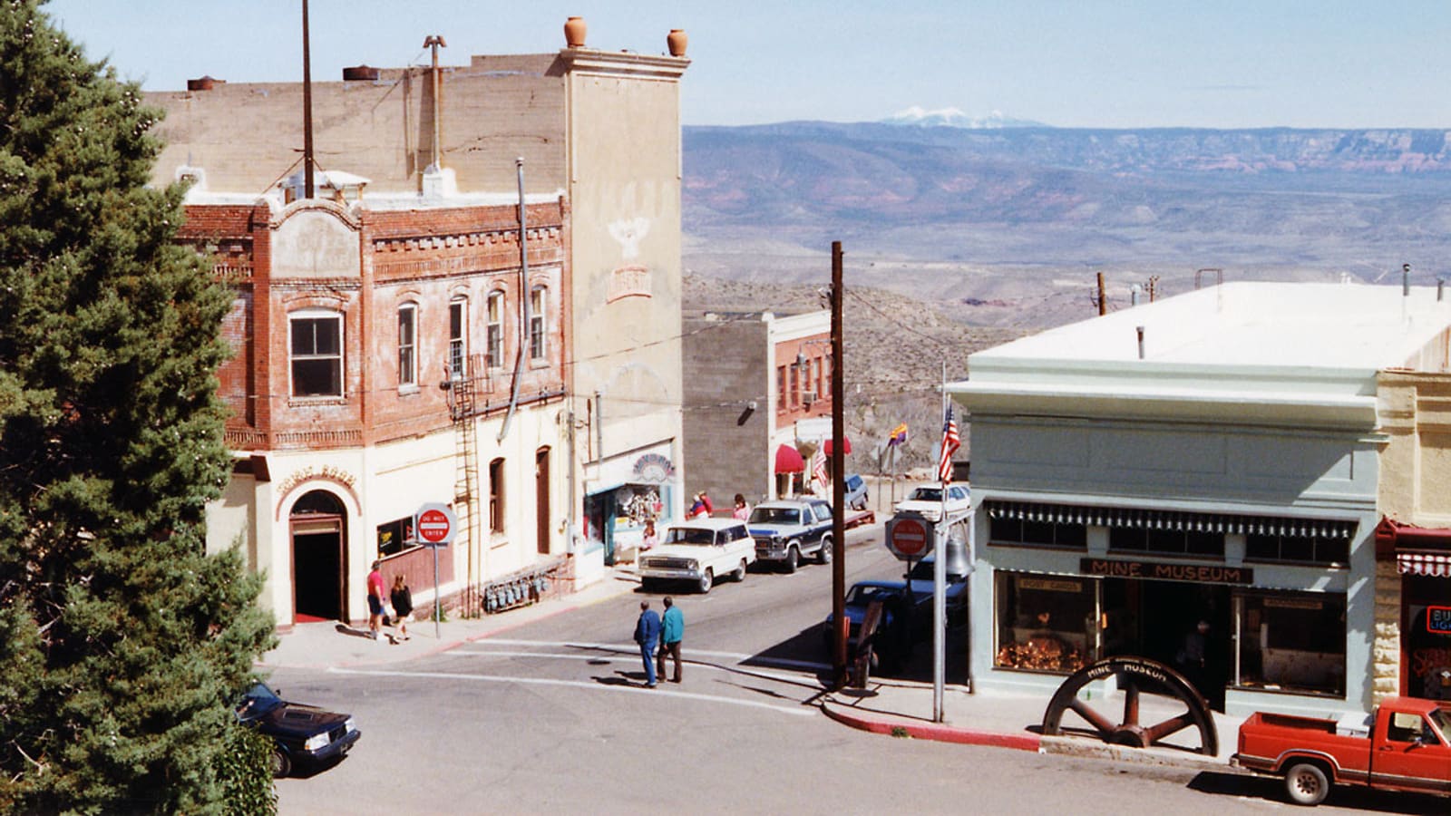 A view down Main Street in Jerome, Arizona, showing the town's historic brick storefronts, including the old Mine Museum building, above the Verde Valley.