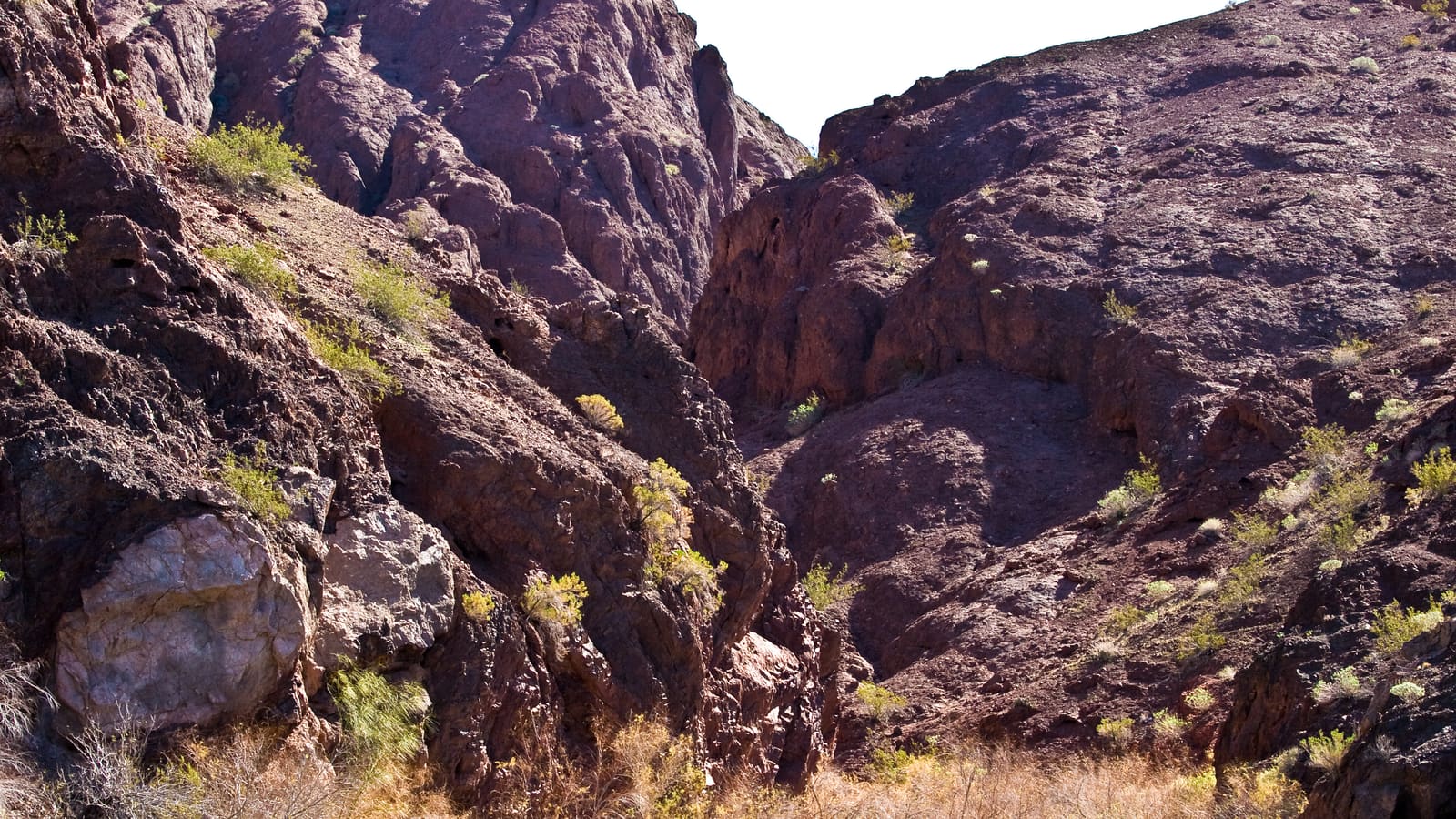 Dark rock walls rising above the Colorado River shoreline in Topock Canyon north of Lake Havasu City, Arizona