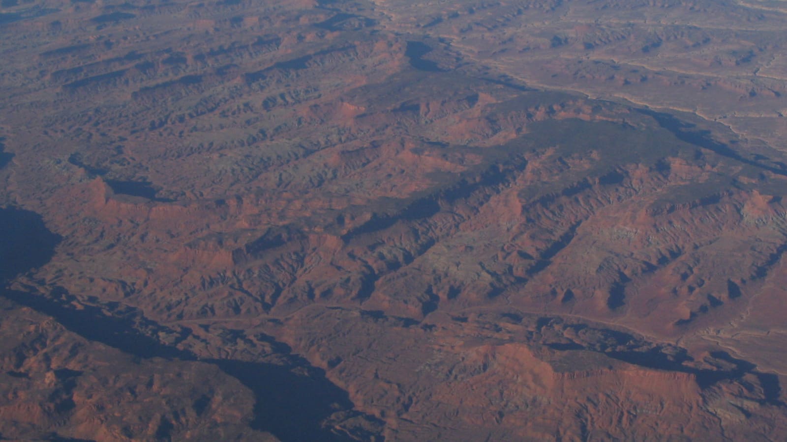 An aerial view of red rock canyons and desert terrain within Glen Canyon National Recreation Area near Lake Powell
