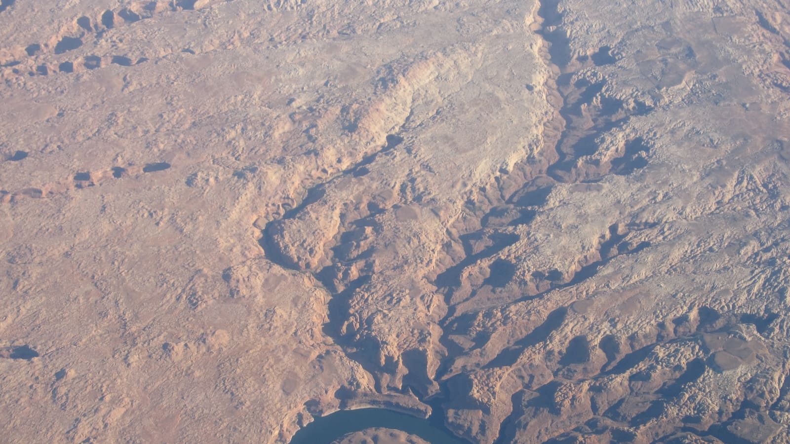 Aerial view of Lake Powell's turquoise water winding between red sandstone canyon walls in Glen Canyon National Recreation Area