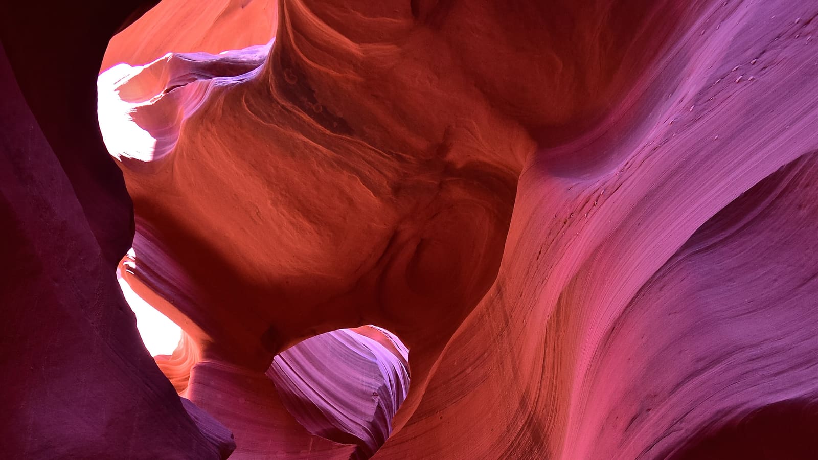 A guided tour group listens to their Navajo guide inside the swirling sandstone walls of Lower Antelope Canyon near Page, Arizona